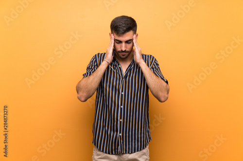 Handsome man with beard over isolated background with headache