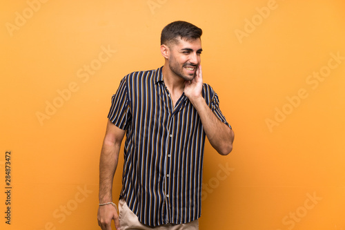 Handsome man with beard over isolated background with toothache
