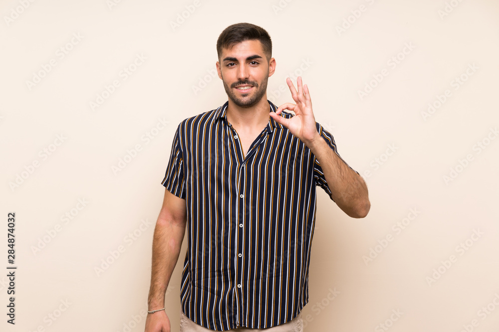 Fototapeta premium Handsome man with beard over isolated background showing an ok sign with fingers