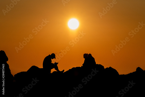 Silhouettes of people at sunrise at the Black Sea