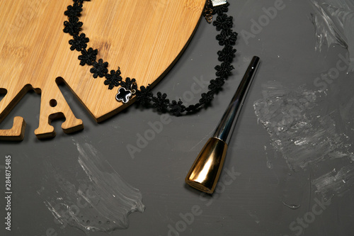 Wooden tray on a gray background with different feminine baubles