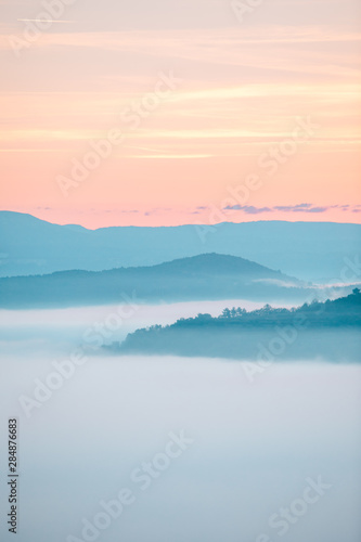 view of sunrise over the mountains mist and clouds under peaks © phpetrunina14