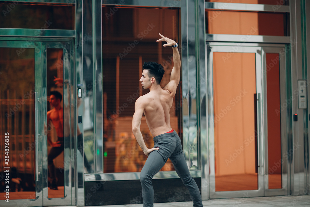Young male ballet dancer on a building background. Outdoor dance. Young male ballet dancer on a building background. Outdoor dance.