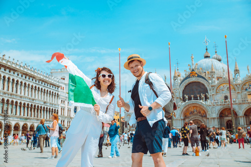 smiling couple holding italian flag venice central square san marco