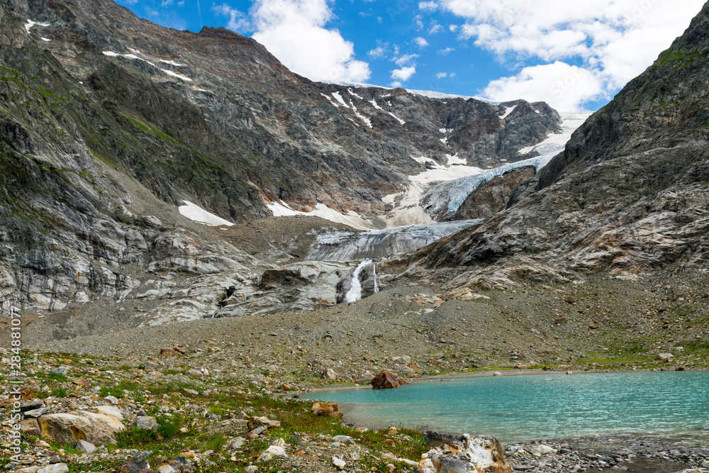 beautiful mountain meadow with beautiful and colorful flowers, glacial lake and mountains beautiful mountain meadow with beautiful and colorful flowers, glacial lake and mountains