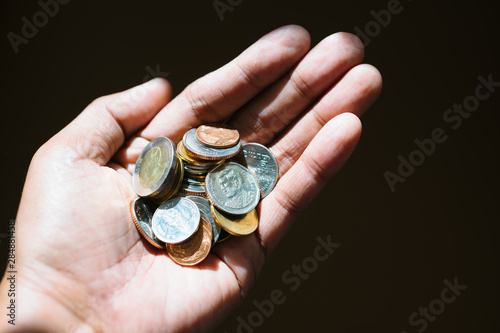Closeup hand hold coins using as financial and money savings concept