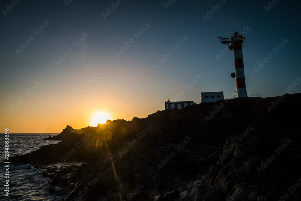 Beautiful scenic landscape with classic lighthouse and golden sunset in background - concept of travel and scenic place. for tourism