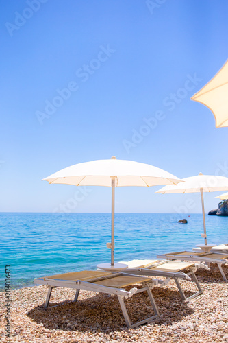 White umbrella and sunbeds at tropical beach