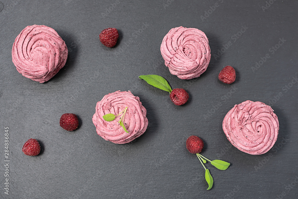 Festive composition with fresh homemade zephyr or marshmallows, raspberries and flowers. Healthy organic dessert concept. Festive composition with fresh homemade zephyr or marshmallows, raspberries and flowers. Healthy organic dessert concept.