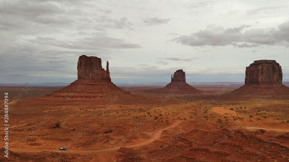 Car is passing by in a cloudy day in Monument Valley