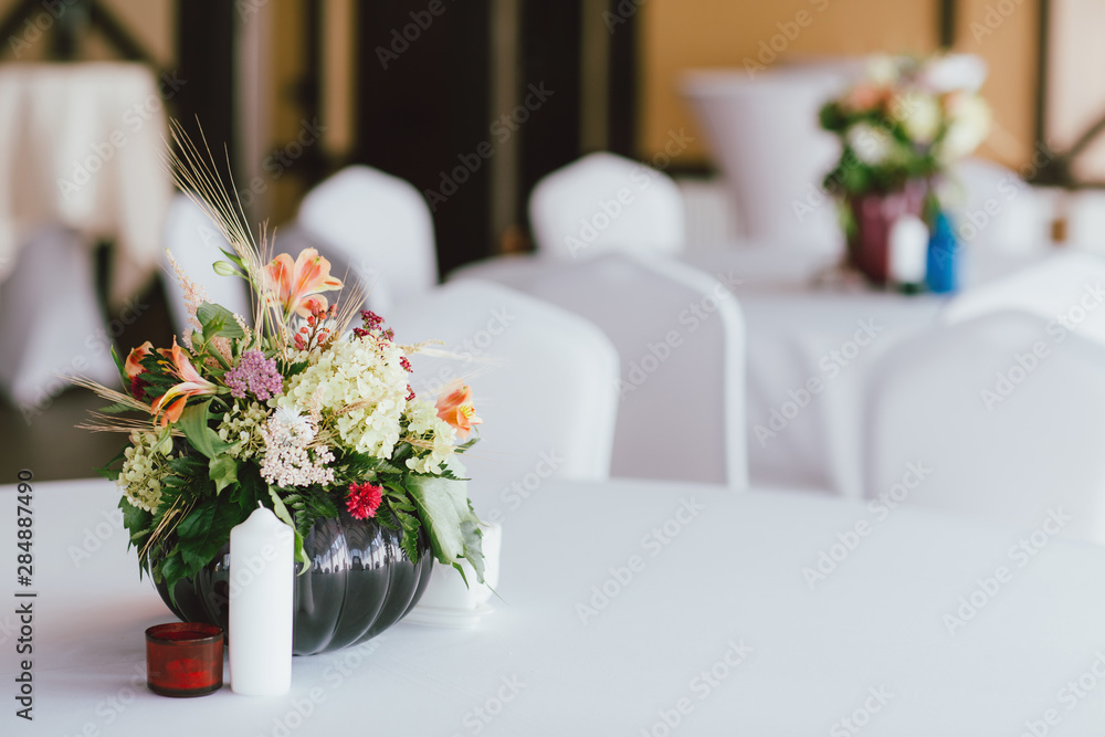 Bouquet of different flowers in a vase on table, preparing for event, wedding