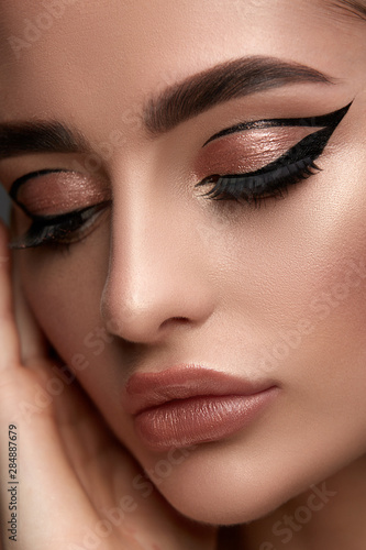 luxury woman make-up with golden shadow and black eyeliner photo