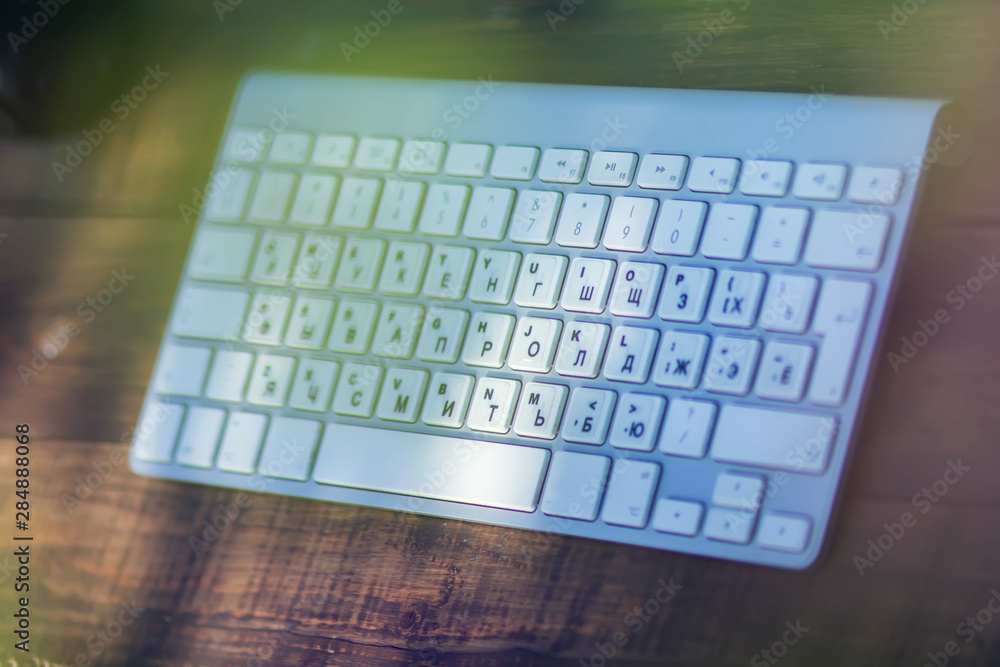 White keyboard on the wooden table. Technology and office concept White keyboard on the wooden table. Technology and office concept