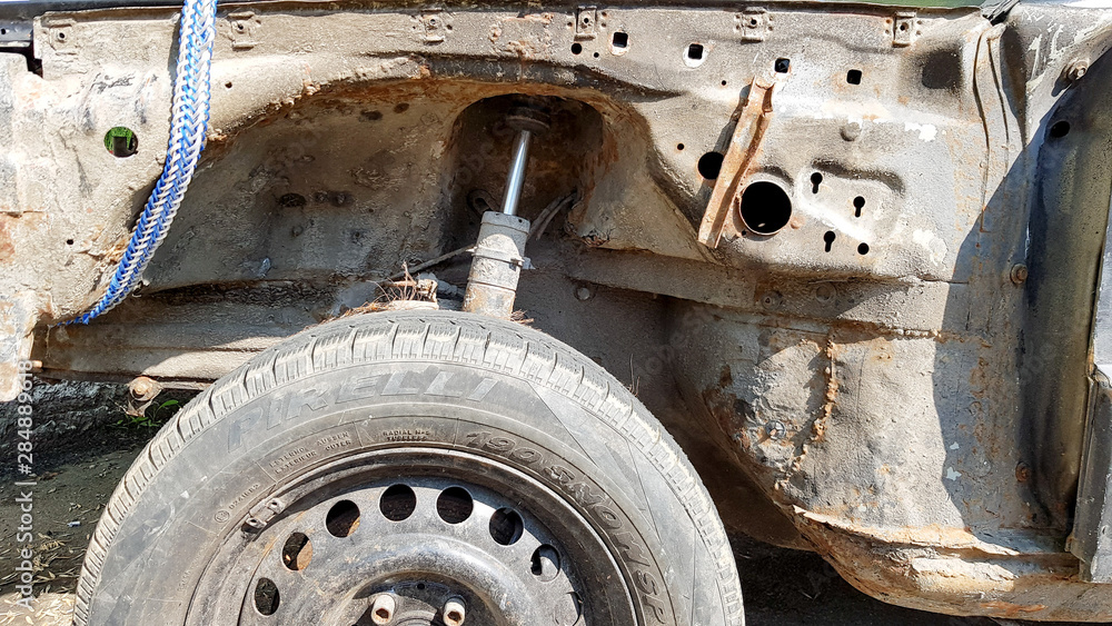 A stand of an old and rusty car closeup. Auto part close-up. A wrecked car at a car service is not subject to restoration and repair A stand of an old and rusty car closeup. Auto part close-up. A wrecked car at a car service is not subject to restoration and repair