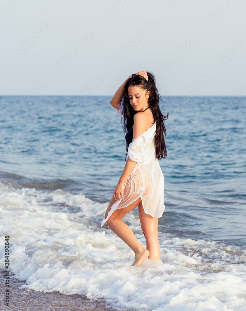 Close up portrait of beautiful young woman on the beach. Young woman model on the seashore. Summer time concept. Close up portrait of beautiful young woman on the beach. Young woman model on the seashore. Summer time concept.