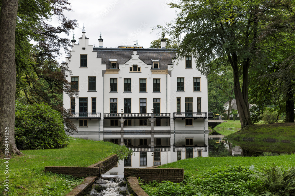 Castle Staverden reflecting in the moat and surrounded by trees