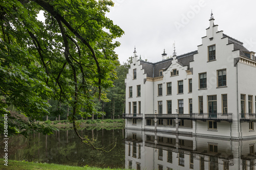 Castle Staverden reflecting in the moat and surrounded by trees