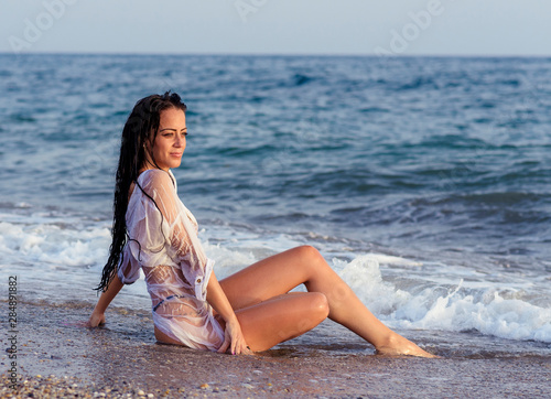 Close up portrait of beautiful young woman on the beach. Young woman model on the seashore. Summer time concept. © Miri García