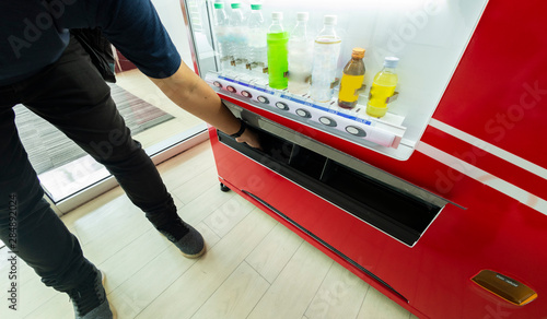 Hand of asian man collecting beverage from automatic dispenser vending machine,technology concept.