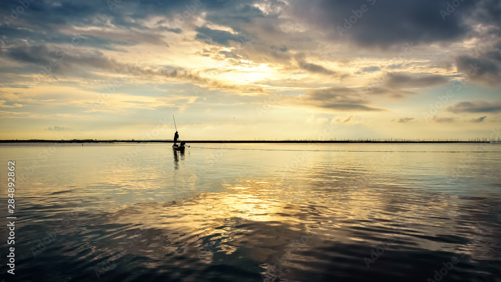 Fisherman on the boat use fishing nets at sunrise, Thailand