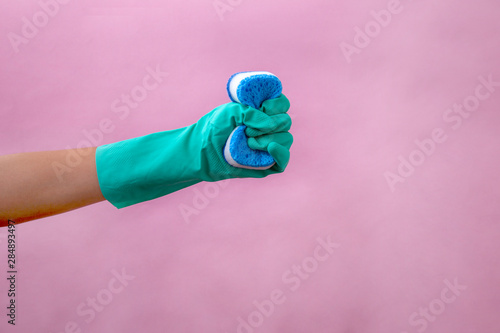 Hands of woman wearing gloves prepared to wash dishes with a sponge