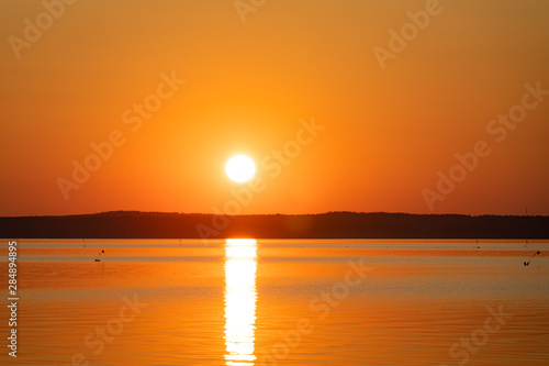 Sunrise above horizon forest at lake