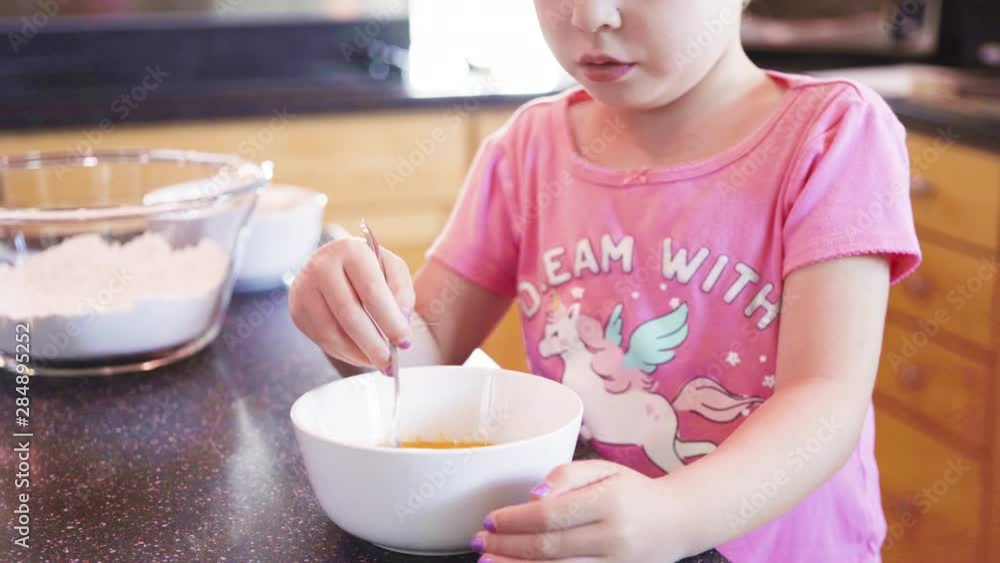Little girl helping bake mini pound cakes in silicone molds shaped as on owls. Little girl helping bake mini pound cakes in silicone molds shaped as on owls.
