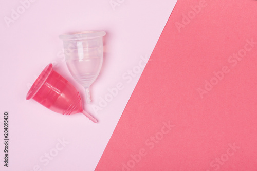 Two menstrual cups close-up on a pink background
