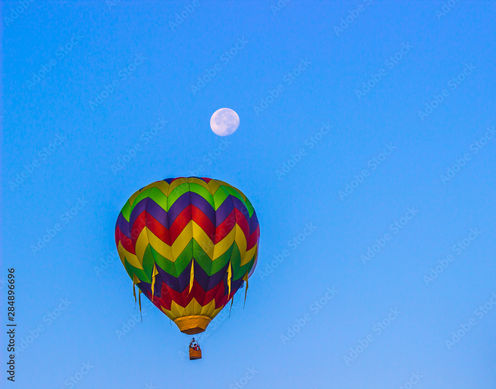 Fototapeta premium Multi Colored Striped Hot Air Balloon With Moon Above