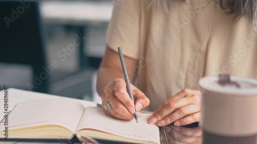 The Woman Is Writing In Her Notebook