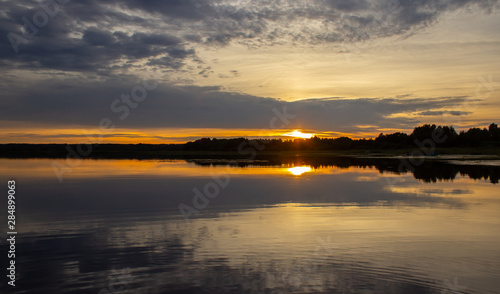 Fototapeta Naklejka Na Ścianę i Meble -  Evening at the lake. Water surface. Beautiful sunset.