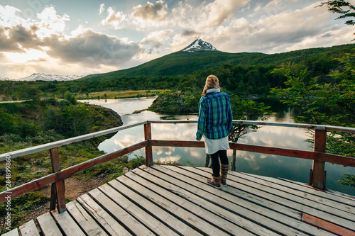 Woman walking in a balcony with a beautiful landscape in the background. Ushuaia, Argentina photo