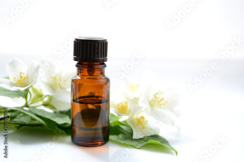 Jasmine oil or essence in a glass bottle for hair and skin. Aromatherapy and Spa concept