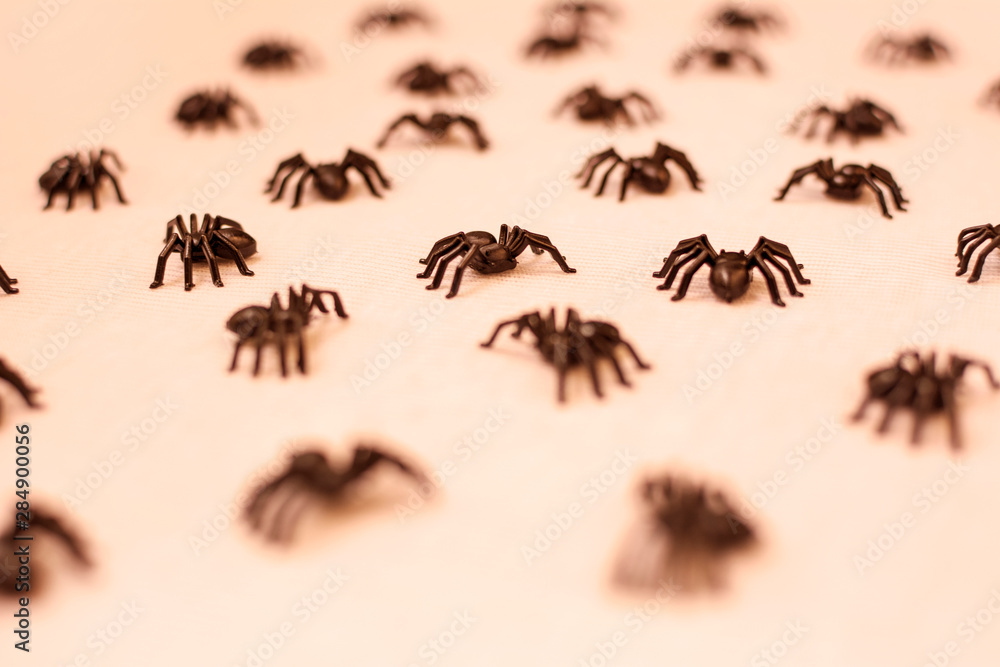 background of many black tarantulas walking on sepia-toned background.