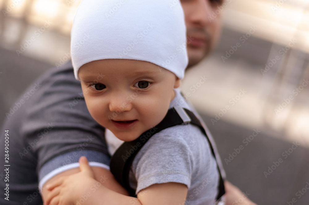 Father with one year old baby in his arms. Walk in an urban environment. The concept of urbanization and life in the city. The development of emotional intelligence. Early development. Father with one year old baby in his arms. Walk in an urban environment. The concept of urbanization and life in the city. The development of emotional intelligence. Early development.