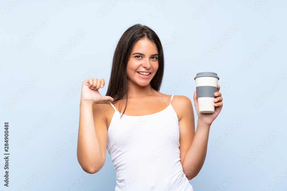 Young woman holding a take away coffee over isolated blue background proud and self-satisfied Young woman holding a take away coffee over isolated blue background proud and self-satisfied