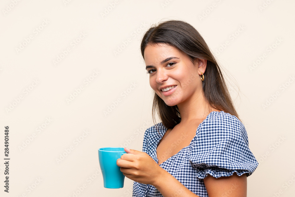 Young girl over isolated background holding hot cup of coffee Young girl over isolated background holding hot cup of coffee