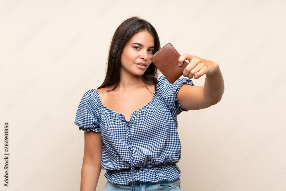 Young girl over isolated background holding a wallet Young girl over isolated background holding a wallet
