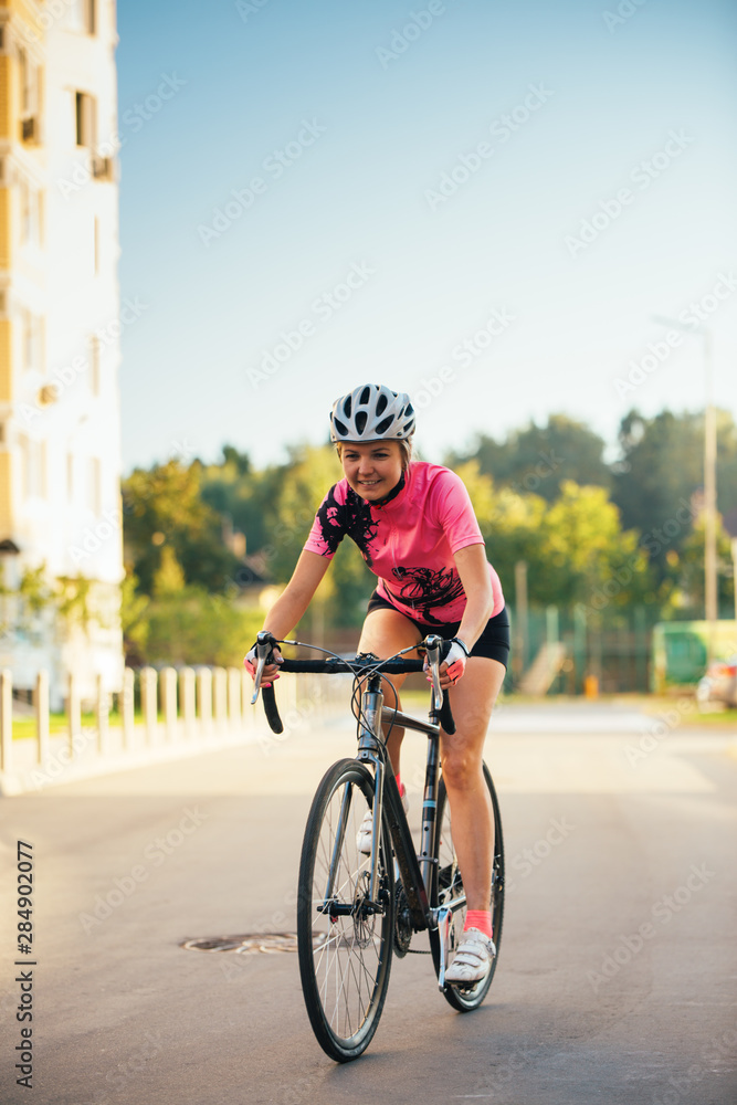 Fototapeta premium Picture of young woman in helmet on bike ride on summer day