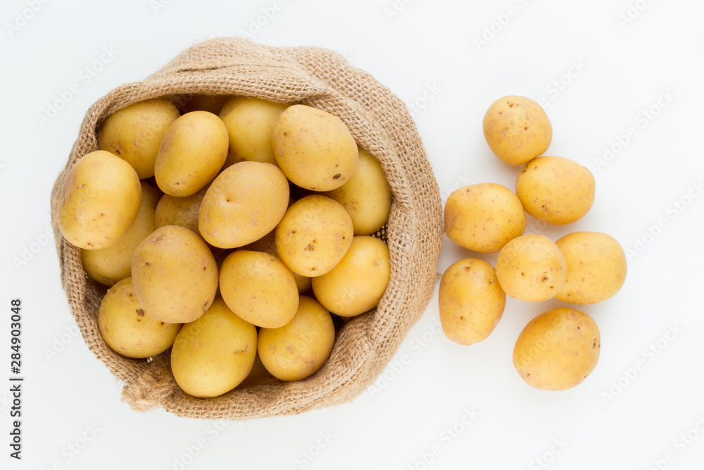 Sack of fresh raw potatoes on wooden background, top view Sack of fresh raw potatoes on wooden background, top view