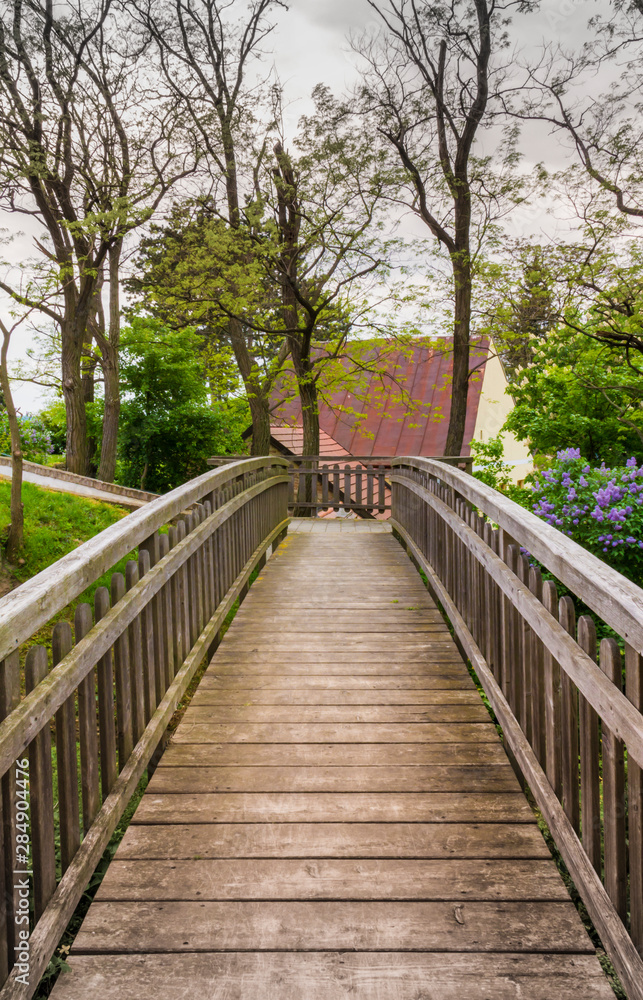 Wooden bridge, trees and roof of house. Wooden bridge, trees and roof of house.
