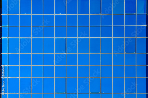 Glass blue square Windows of facade modern city business building skyscraper. Modern apartment buildings in new neighborhood. Windows of a building, texture. © polack