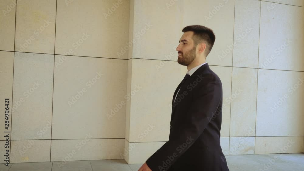 Happy businessman walking around city, successful and self-confident man on the background of a modern building. Happy businessman walking around city, successful and self-confident man on the background of a modern building.