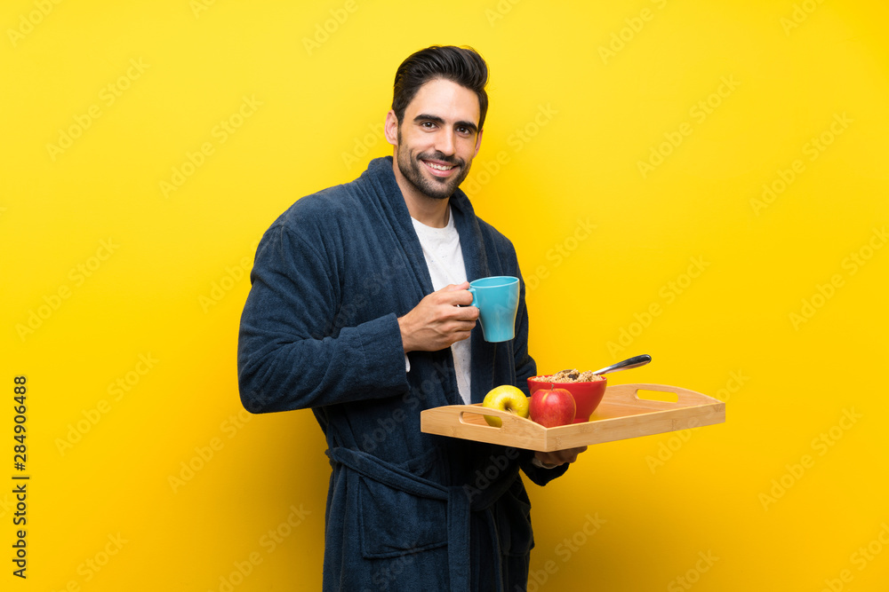 Handsome man in pajamas over isolated yellow wall Handsome man in pajamas over isolated yellow wall