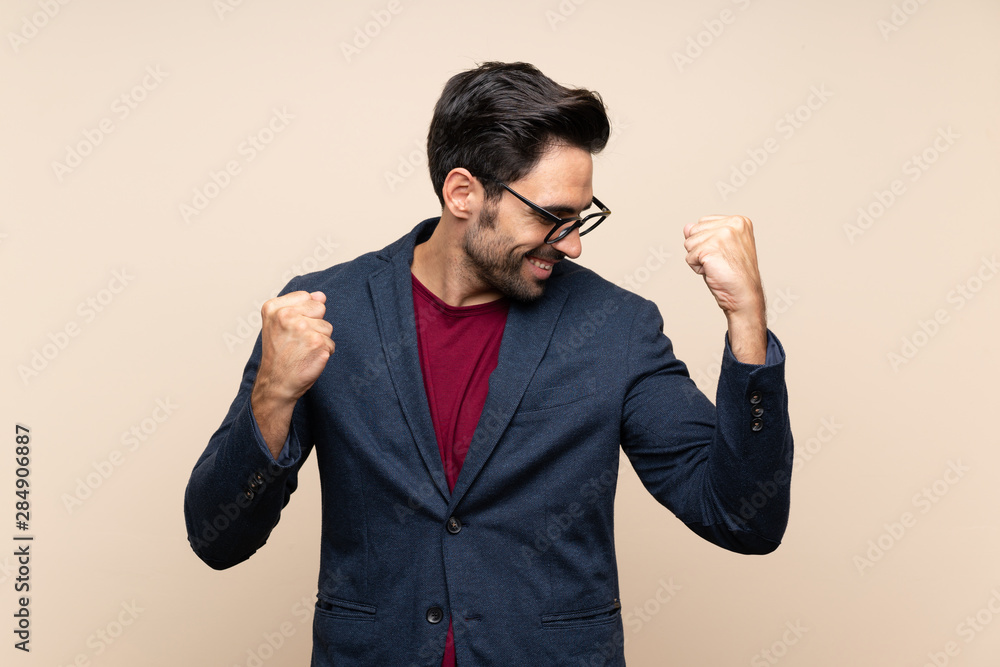 Handsome young man over isolated background celebrating a victory Handsome young man over isolated background celebrating a victory