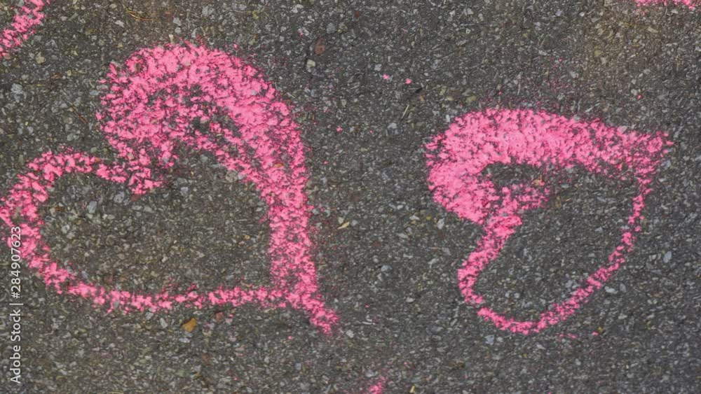 Cute pattern of many pink hearts drawn on grey texture of sidewalk by chalks. 4k video footage. Cute pattern of many pink hearts drawn on grey texture of sidewalk by chalks. 4k video footage.