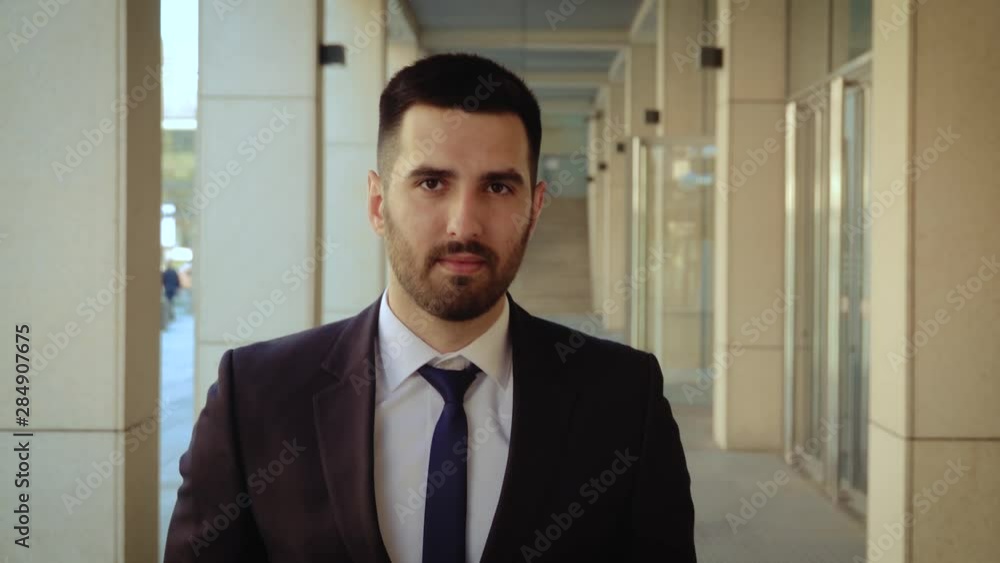 Happy businessman walking around city, successful and self-confident man on the background of a modern building. Happy businessman walking around city, successful and self-confident man on the background of a modern building.