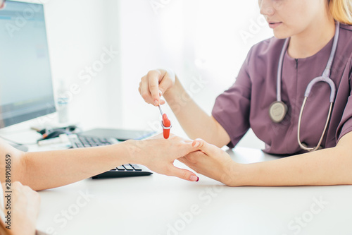 Neurological examination. The neurologist testing hand reflexes on a female patient using a hammer. Diagnostic, healthcare, medical service photo