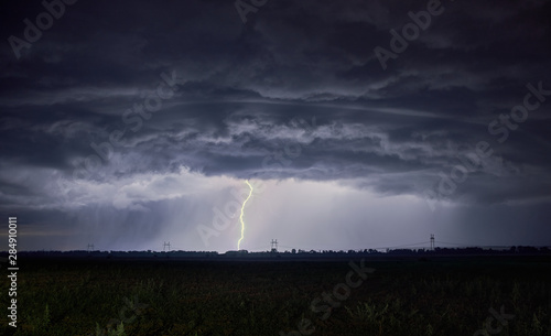 Unrealistically beautiful thick clouds and lightning strike into the ground