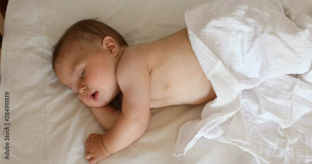 View from above of the newborn baby, close up shot. A cute little baby sleeping View from above of the newborn baby, close up shot. A cute little baby sleeping
